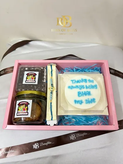 A top-down view of the hamper, showing the "Thanks for always being by my side BHAI" message on the bento cake.