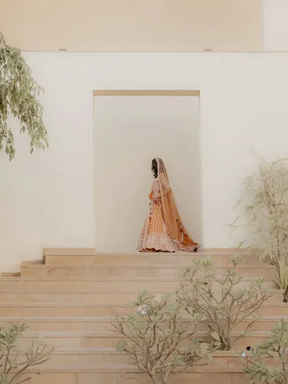 The bride walking up the stairs, her beautiful lehenga trailing behind her. This is a graceful and elegant shot that feels like a painting.
