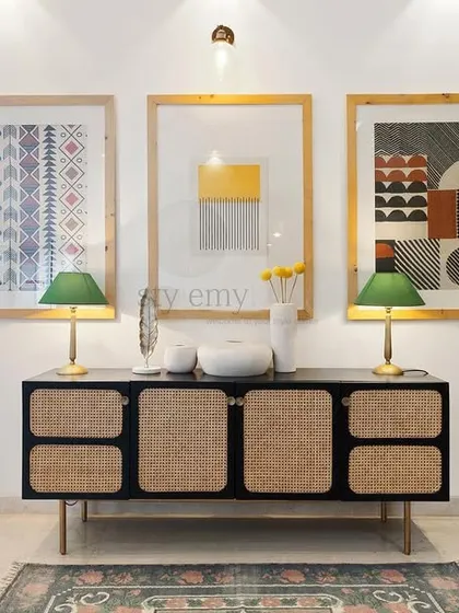 A wider view of the cane side cabinet, showing how it anchors the entryway and complements the modern art and decor.