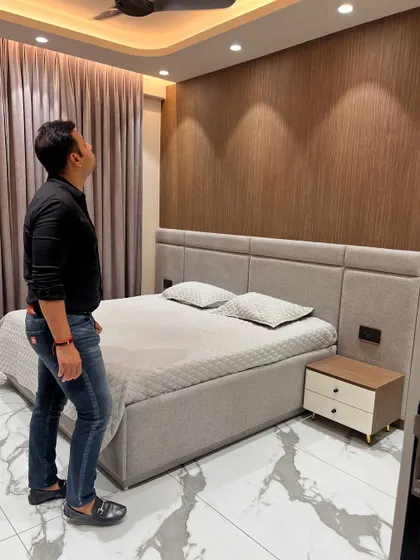 Admiring the final look of the bedroom. The combination of wood texture, fabric, and soft lighting creates a very calming space.