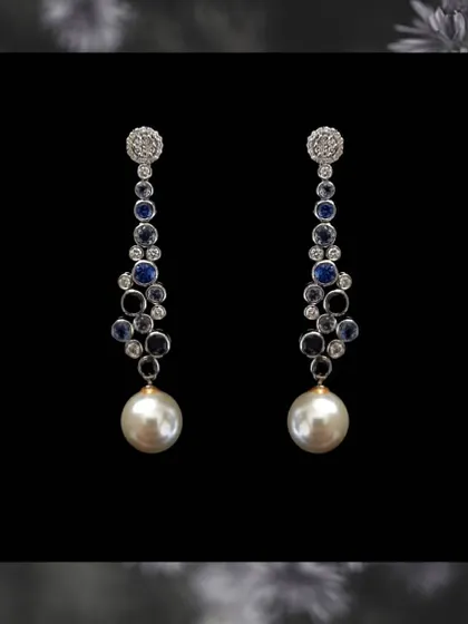 A classic combination of blue sapphires, diamonds, and a large south sea pearl drop. These long earrings are the epitome of elegance and are perfect for an evening event.