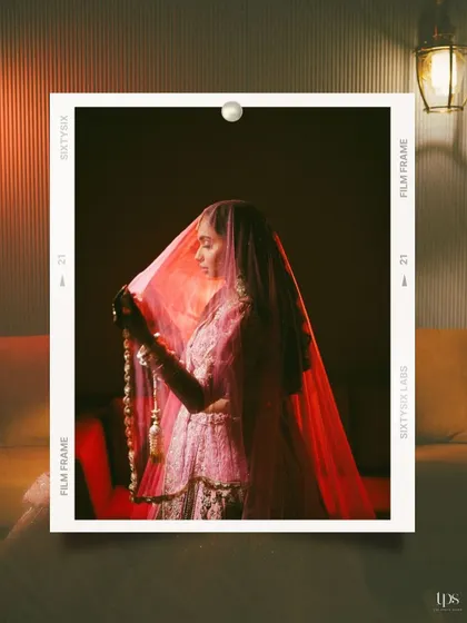 A stunning, artistic bridal portrait with a film-frame border. The dramatic lighting on the bride's veil creates a mysterious and beautiful image.