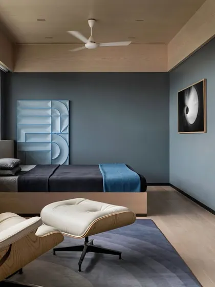 In the son's bedroom of 'A Hint of Azul', a long console runs the length of the window and transforms seamlessly into the bed's headboard. This custom furniture piece unifies the long, cuboidal space.