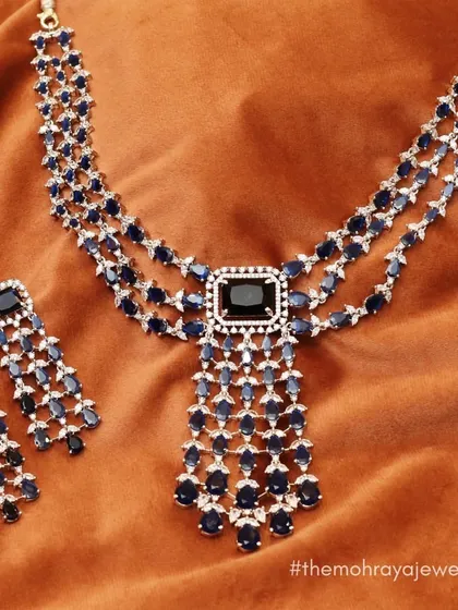 A stunning three-layered necklace with deep blue stones, perfect for making a statement at a reception or sangeet.