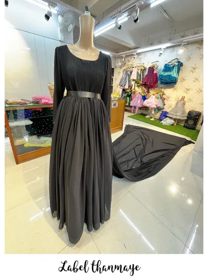 An elegant black long-sleeved gown with a flowing georgette skirt and a long trail.