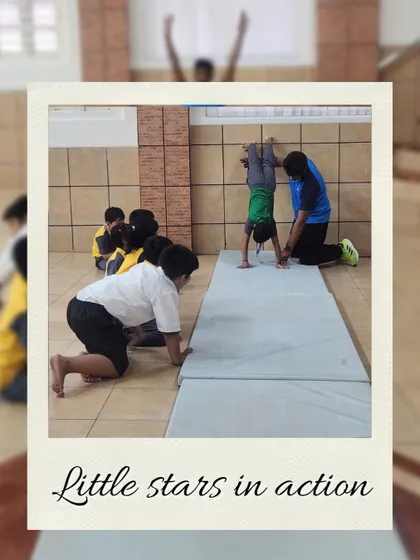 Little stars in action. A coach assists a young child with a handstand on a gym mat, providing safe and encouraging guidance to build their confidence and gymnastic skills.