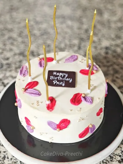 A minimalist cake that makes a statement with a pop of color. I used a palette knife to create abstract petal-like strokes of red and purple buttercream on a clean white canvas.