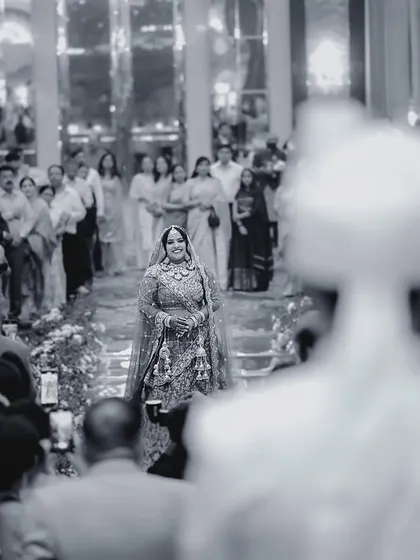The bride's entry, captured in black and white from the groom's perspective, emphasizes the emotion of seeing her walk down the aisle.