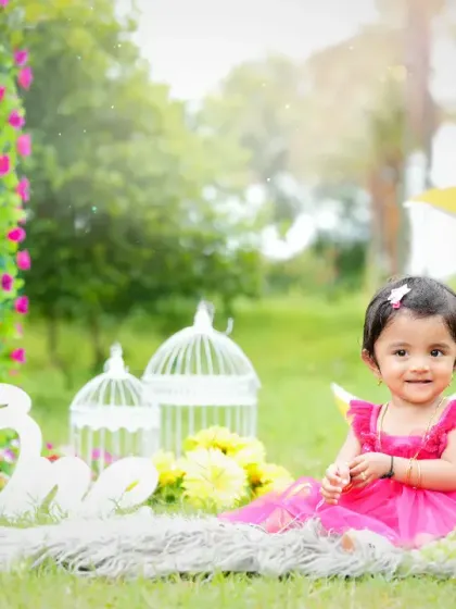 Capturing the magic of childhood outdoors, this little girl celebrates her first birthday in a beautiful garden setting. The natural light and whimsical props like the crescent moon and birdcages create a dreamy, fairytale atmosphere.