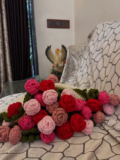 A close-up look at the "bouquet" part of the blanket. I used various shades of pink and red yarn to create these 32 crochet roses, giving the border a lush, three-dimensional look.