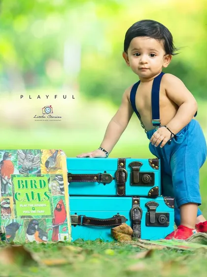 A playful portrait of a curious toddler. I often use props like these colorful vintage suitcases and classic books to engage children and bring out their natural charm during a shoot.