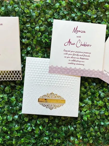 This clean and contemporary wedding invitation set uses a simple white and burgundy color scheme. The main card features a textured finish and a gold foil accent, with matching inserts for the engagement and wedding ceremony details.