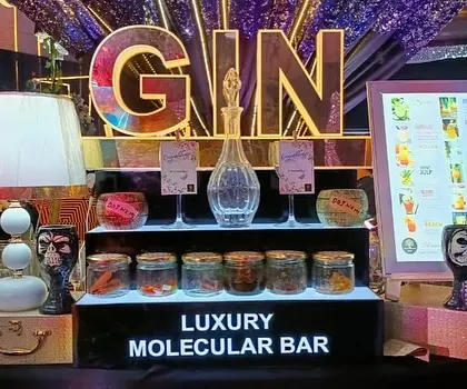 A dedicated gin tasting station, complete with a variety of botanicals in glass jars for guests to explore, flanked by digital menus.