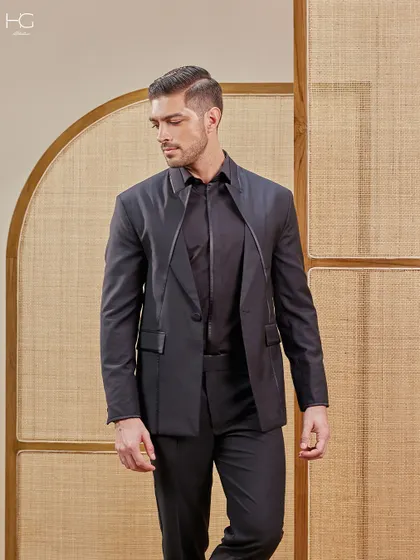 Here is another take on an extraordinary all-black suit. The unique lapel design that extends over the shoulder creates a sartorial elegance that is both modern and memorable.