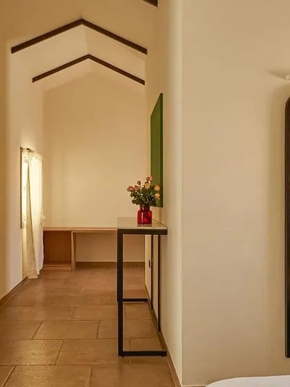 A view from the bedroom into the corridor of the guest suite. The design uses clean lines and a simple color palette to create a sense of tranquility.