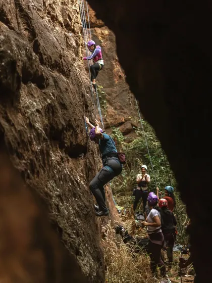 Two climbers ascend parallel routes in a narrow canyon. This image showcases the shared experience of climbing, even when on your own rope.