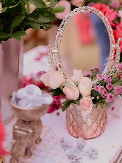 A close-up of a vanity-style corner at a Chooda ceremony, with a vintage silver mirror reflecting blush roses, creating a delicate and feminine vignette.