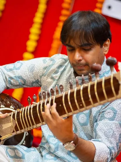 Deep in concentration during a recital of Raag Parmeshwari. This image shows the intricate posture and technique involved in playing the sitar.