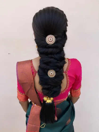 I created this twisted, messy braid and accessorized it with two large, round, stone-studded hairpins for a modern yet traditional look.