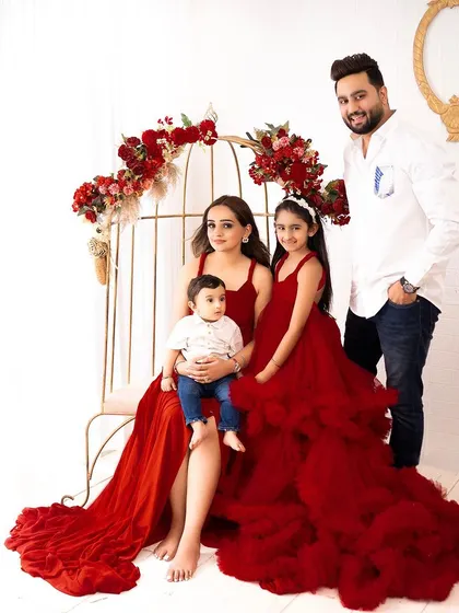 A stunning family portrait with everyone dressed in rich red tones. The mother and daughters wear beautiful matching gowns from my client closet.