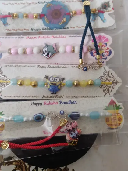 I have so much fun creating rakhis for everyone. This image shows a variety of my custom rakhis, including playful designs with cartoon characters for kids and elegant evil eye or floral resin rakhis for older brothers.