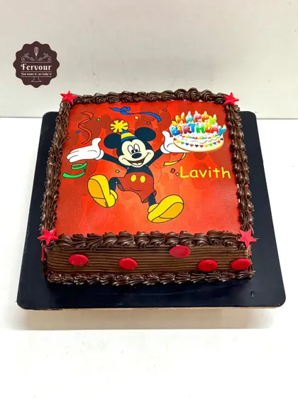A bright and cheerful Mickey Mouse photo cake. This square chocolate truffle cake features a vibrant edible image of Mickey, surrounded by a piped border and festive stars.