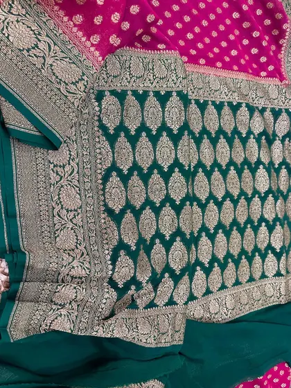 The rich pallu of the green and pink pure Banarasi Kadi georgette saree. The dense leaf-patterned weaving in gold zari is truly a work of art.