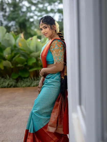 A full-length side profile. The makeup and hairstyle are perfectly coordinated with the stunning saree.