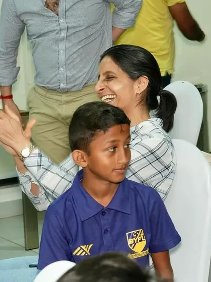 A mother proudly applauding her son's achievements.