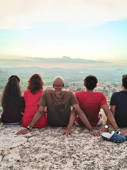 It's not just about the trek, it's about the moments in between. Finding a perfect spot to sit, sharing stories, and just soaking in the view together. This is the community vibe we create on every trip, like this sunset session in Hampi.