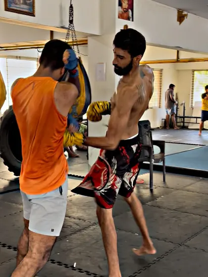 I demonstrate a body shot counter during a light sparring drill. This teaches students how to react to an opponent's attack.