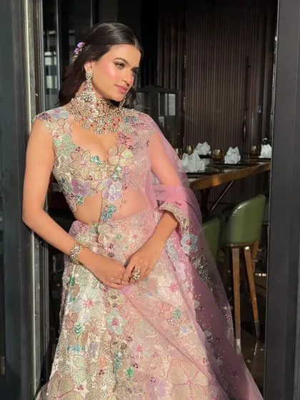 A detailed shot showing the texture and artistry of the floral embroidery on this pastel lehenga, a true work of art.