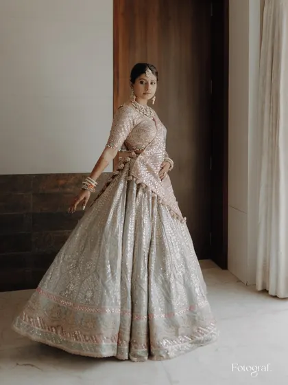 A bride twirls in her stunning pastel lehenga, the movement showing off the beautiful flow and design of the outfit.