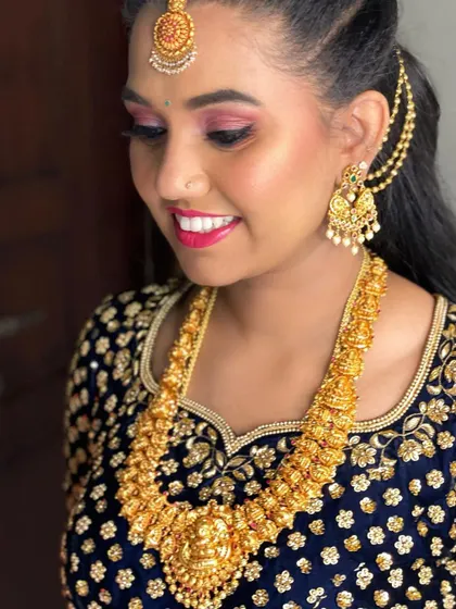 Another look at Nisha's party makeup. The focus is on her bright, happy expression, enhanced by a clean makeup application and a traditional hairstyle with side detailing.