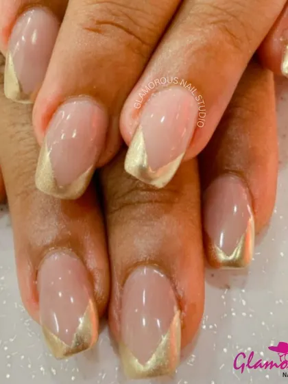 A modern and chic take on the French manicure, this design features a V-shaped tip in metallic gold on a natural base.