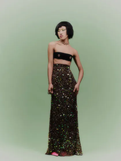A complete view of the look, where the jewelry adds a touch of opulence to the minimalist bandeau top and sparkling skirt.