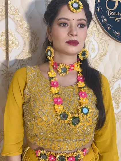 Another angle of the Haldi look with paper flower jewellery, showing the full set including earrings and `maang tikka`.