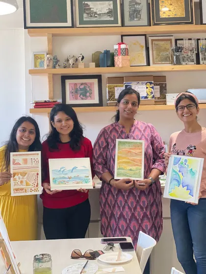 Four participants showing off their beautiful watercolor creations from a weekend workshop.