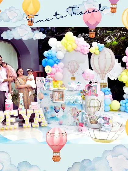 We took flight with a hot air balloon travel theme for Reya's birthday. The decor featured a sky blue backdrop, fluffy cloud and hot air balloon props, and pastel balloon garlands, creating a sense of adventure and wonder.