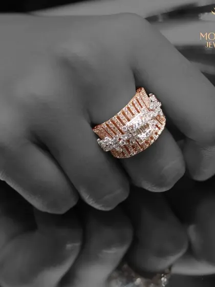 A wide, architectural ring with baguette and round diamonds. The black and white image emphasizes the texture and geometric quality of this powerful, modern piece.