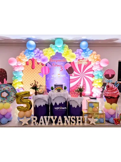 A sweet Candyland theme for a 5th birthday, filled with giant candy props and a pastel balloon arch.