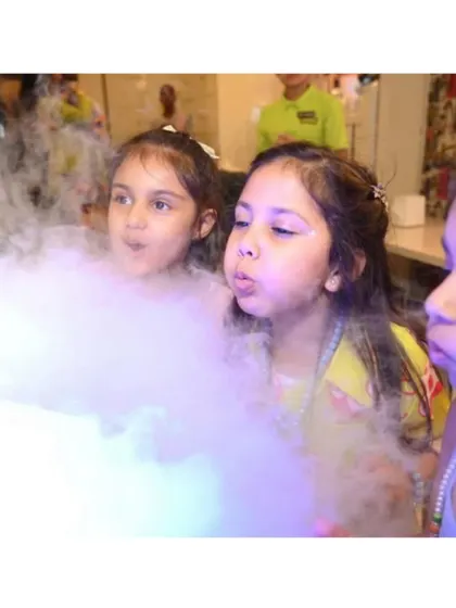 Kids are amazed as they interact with the dry ice smoke from a science-themed activity.