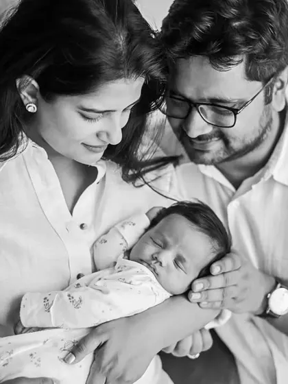 A classic black and white family portrait with a sleeping newborn. The monochrome tones add a timeless quality, focusing all attention on the love and connection within the family.