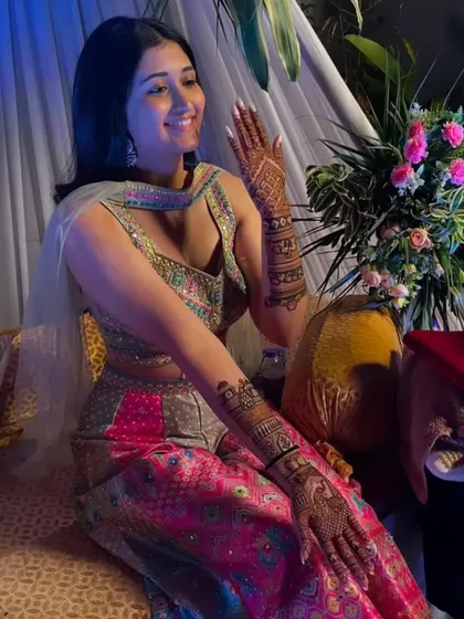 A candid shot of a happy bride, her hands adorned with our intricate mehandi.