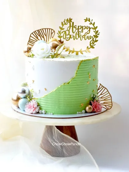 This is my take on the modern fault line cake trend. I used a combination of textured green and smooth white buttercream, highlighted with edible gold leaf for an elegant touch. It's a Choco Raspberry cake, perfect for a sophisticated birthday celebration.