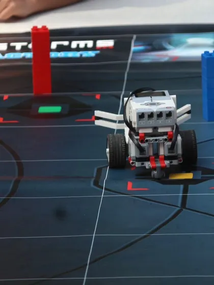A LEGO Mindstorms robot positioned on a challenge mat during an IRO orientation. This demonstrates the type of advanced robotics our students learn to build and program.