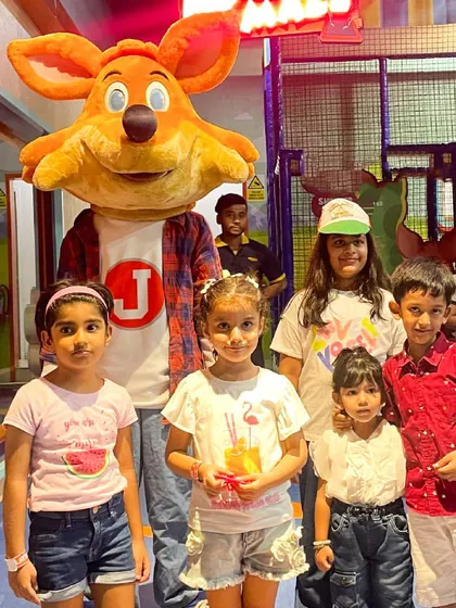 J the Fox stands proudly with a group of children during our Independence Day event, creating a memorable moment for everyone.