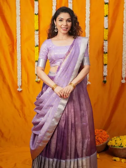A model wearing a beautiful lavender half-saree or lehenga saree. This is a modern and convenient style, perfect for young women and festive events.