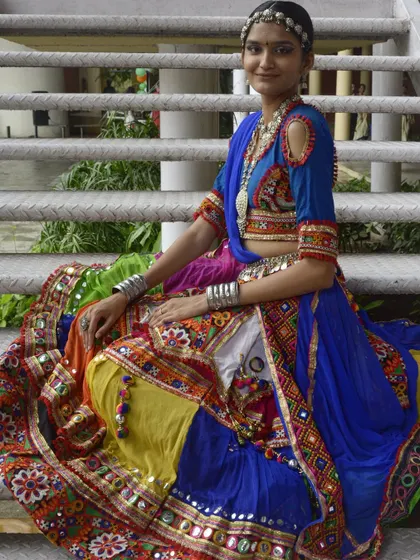 A vibrant multi-colored chaniya choli with a royal blue blouse and dupatta. The oxidized silver jewelry completes this traditional look.
