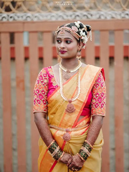 A classic bridal portrait against a simple background, allowing the bride's beauty, her attire, and jewelry to be the main focus.